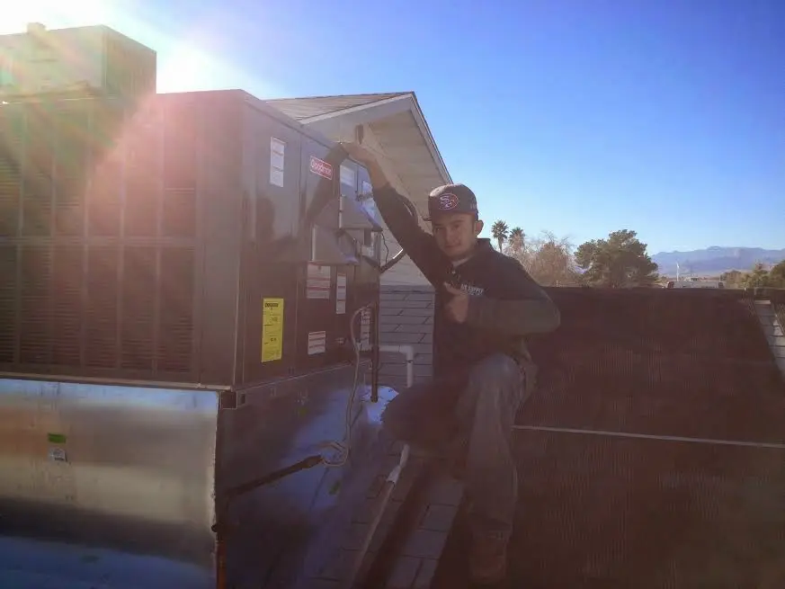 HVAC technician performing AC Tune-Up on a rooftop unit in Ashton-Sandy Spring